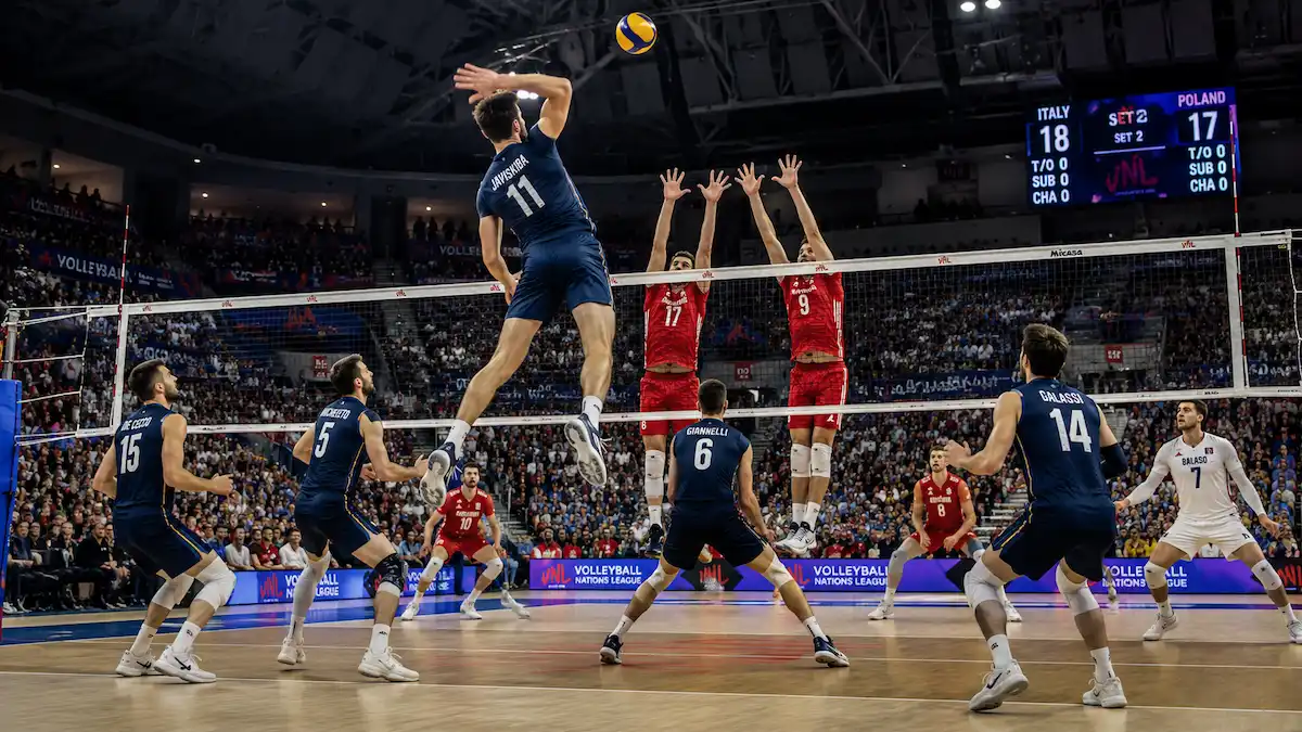 Male volleyball player in a dark navy blue uniform jumping high to spike the ball over the net while two players in red uniforms attempt a block during an indoor volleyball match.
